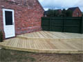 Wooden decking on two levels to create a walkway from the kitchen to the garage