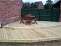 Wooden decking on two levels to create a walkway from the kitchen to the garage